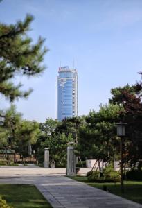 een hoog gebouw op de achtergrond van een park bij Crowne Plaza Xi'an, an IHG Hotel in Xi'an