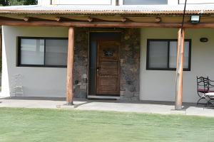 - une terrasse couverte à l'avant d'une maison avec une porte en bois dans l'établissement Finca Ogawa, à Los Sauces