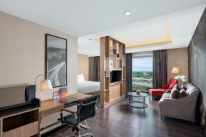 um quarto de hotel com uma cama e uma sala de estar em Swiss-Belhotel Airport Jakarta em Tangerang