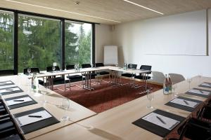 einen Konferenzraum mit Tischen und Stühlen und einem großen Fenster in der Unterkunft Hôtel de Gruyères in Gruyères