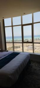 1 dormitorio con cama y vistas a la playa en همم للوحدات السكنيه المخدومة- الدقم en Umm Lajj