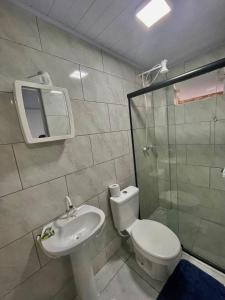 y baño con aseo, lavabo y ducha. en Hangar Pousada en Navegantes