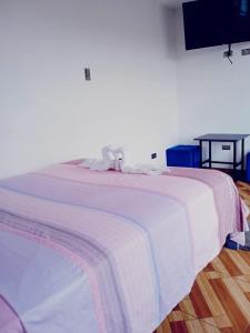 Una cama con una manta blanca encima. en Tumalki rooms en Trujillo