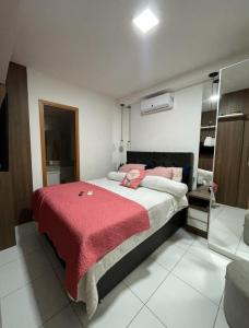 a bedroom with a large bed with a red blanket at Apto completo com varanda e garagem em Brasília in Brasilia