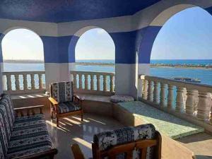 balcón con sillas y vistas al agua en بورتو مارينا en El Alamein