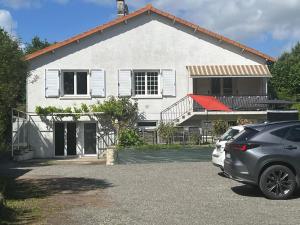 una casa blanca con un coche aparcado delante de ella en Logis de Bois Vert en Bressuire