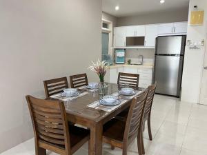 een keuken met een houten tafel met stoelen en een koelkast bij Kinrara Puchong Bukit Jalil Sunway 3 bedroom condo comes with 2 parking in Puchong