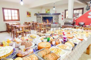 una línea de buffet con muchos tipos diferentes de comida en VELINN Hotel Ninho do Falcão, en Monte Verde