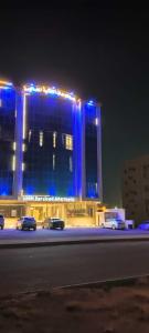 un gran edificio con luces azules por la noche en همم للوحدات السكنيه المخدومة- الدقم en Umm Lajj