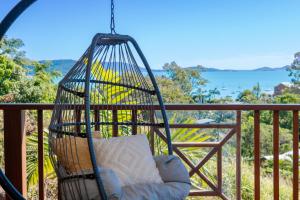 een schommel op een balkon met een kussen erin bij Coral Sea Views in Airlie Beach