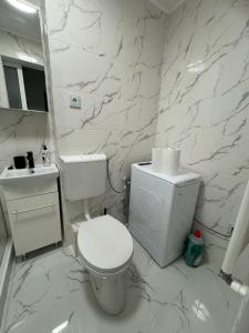 a white bathroom with a toilet and a sink at Apartament modern, totul nou, in centrul orasului in Giurgiu