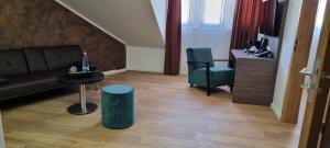 sala de estar con sofá, mesa y silla en Central Hotel & Lounge Adult Only en Goslar