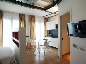 une chambre avec une table et des chaises ainsi qu'une cuisine dans l'établissement BB Hotels Aparthotel Isola, à Milan