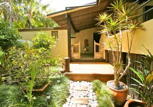 una casa con un jardín con plantas delante de ella en Auwas Island Holiday Home en Burnt Pine