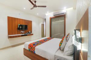 a bedroom with a bed and a flat screen tv at FabHotel Raj Palace in Lucknow