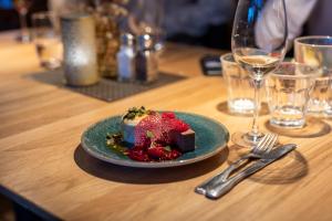 une assiette de dessert sur une table avec un verre de vin dans l'établissement Hestraviken Hotell & Spa, à Hestra