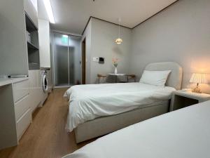 - une chambre avec un grand lit blanc et une fenêtre dans l'établissement Muadejavu Dongdaemun, à Séoul