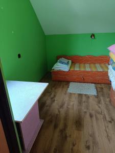 Camera verde con letto e pavimento in legno di Bieszczadzkie Spanie Cisna 9 a Cisna