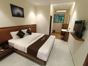 1 dormitorio con 1 cama grande y TV en Moon Lite Residency - Malad West, en Bombay