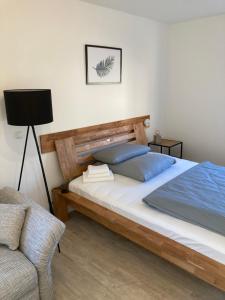 um quarto com uma cama grande e uma cadeira em MEINpartments - Modern Business Apartment em Wolfsburg