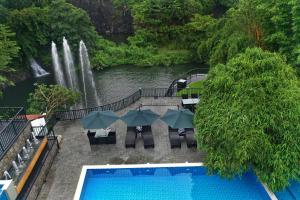 una piscina con una cascada en el fondo en Athirapally Green Trees en Athirappilly