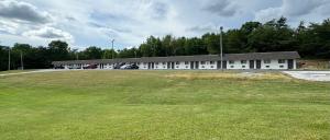 un grande edificio con un grande campo di fronte ad esso di Economy Inn a Crossville