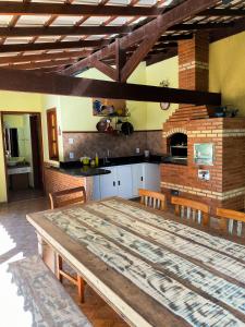 uma cozinha com uma grande mesa de madeira num quarto em Chalé vista dos Nobres em Domingos Martins