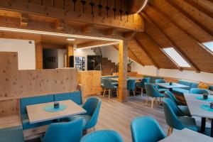 een eetkamer met blauwe stoelen en tafels bij Self Service Hotel Schnalser Hof in Naturno