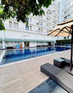 a swimming pool in a building with an umbrella at DLF Stay in Lucknow