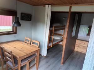 Habitación con mesa, sillas y litera en Torne Camping - Kano & Fiskecamp, en Grimslöv