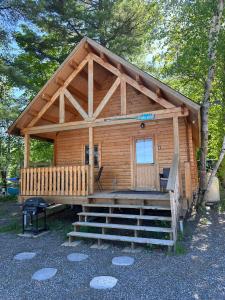 パリーサウンドにあるLakeside Cottage On Muskoka Shoresのポーチと階段付きの大きな木造キャビン