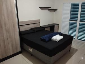 een slaapkamer met een bed met twee handdoeken erop bij Casa com piscina in São José dos Campos