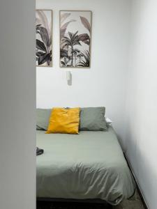 een bed in een kamer met drie foto's aan de muur bij Habitación cerca de Las Canteras in Las Palmas de Gran Canaria