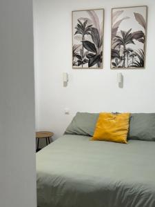 een slaapkamer met een bed met twee foto's aan de muur bij Habitación cerca de Las Canteras in Las Palmas de Gran Canaria