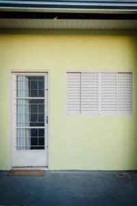 un garaje blanco con puerta y ventana en Casa de gente Feliz, en Cuiabá