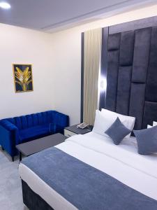 una camera con un grande letto e un divano blu di The Mayrock Hotel ad Abuja