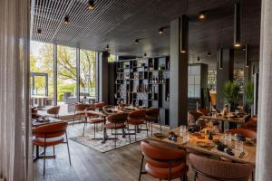 een restaurant met tafels en stoelen en een boekenplank bij Hedon Spa & Hotel in Pärnu