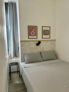 a bed in a bedroom with two pictures on the wall at Apartamento Chic Centro in Dos Hermanas