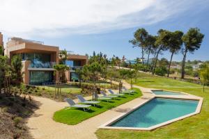 a house with a swimming pool and lounge chairs at Palmares Signature Apartments in Lagos