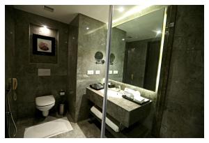 La salle de bains est pourvue d'un lavabo, de toilettes et d'un miroir. dans l'établissement Best Western Plus Tejvivaan, à Visakhapatnam