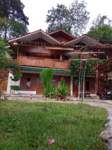 una casa con un patio delante de ella en Monkey Business Tours and Accommodation en Bukit Lawang