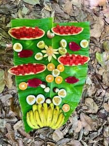 un montón de frutas en una hoja verde de plátano en Monkey Business Tours and Accommodation en Bukit Lawang