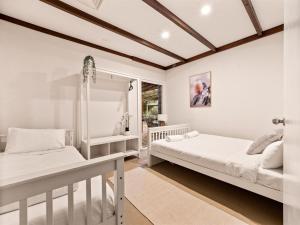 two beds in a white room with a window at Blissful Escape Holiday Home in Margaret River Town