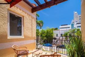 einen Balkon mit Stühlen und Tischen sowie Straßenblick in der Unterkunft Kasa La Flora and Impala Miami Beach in Miami Beach