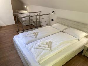 uma grande cama branca com lençóis brancos e almofadas brancas em M3-Apartmány em Martin