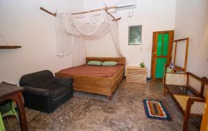 1 dormitorio con 1 cama y 1 silla en Hilltop Bungalow, en Mirissa