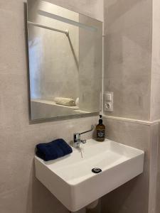 y baño con lavabo blanco y espejo. en Apartamentos Matilda, en Conil de la Frontera