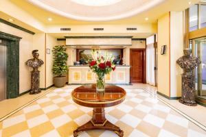 eine Lobby mit einem Tisch und einer Blumenvase in der Unterkunft Hotel Internazionale in Bologna