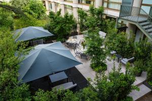 einen Blick über eine Terrasse mit Tischen und Sonnenschirmen in der Unterkunft Hotel Internazionale in Bologna