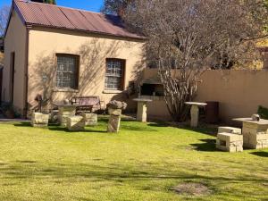 een huis met een tuin met een bankje ervoor bij Cherry Lane Guest House in Ficksburg